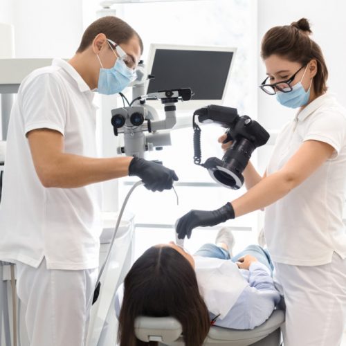 Snapping the result. Skillful dentists taking photo with professional camera of patient teeth